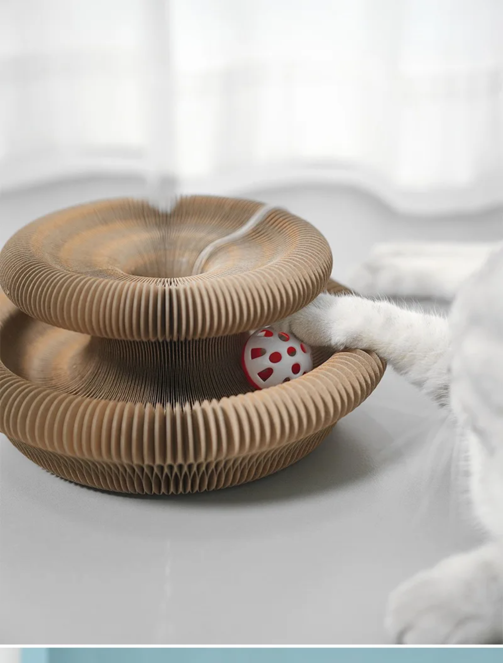Nahaufnahme des Glöckchenballs mit Katzenpfote an der Catfri FoldScratcher
