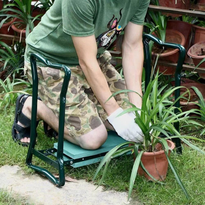 Mann kniet bequem auf der gepolsterten KneeBench beim Pflanzen im Beet