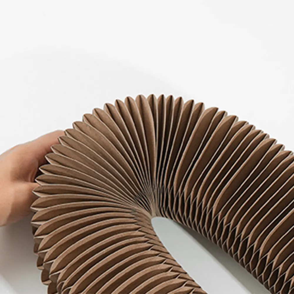 Hand hält die ausgezogene Wellpappstruktur der Catfri FoldScratcher