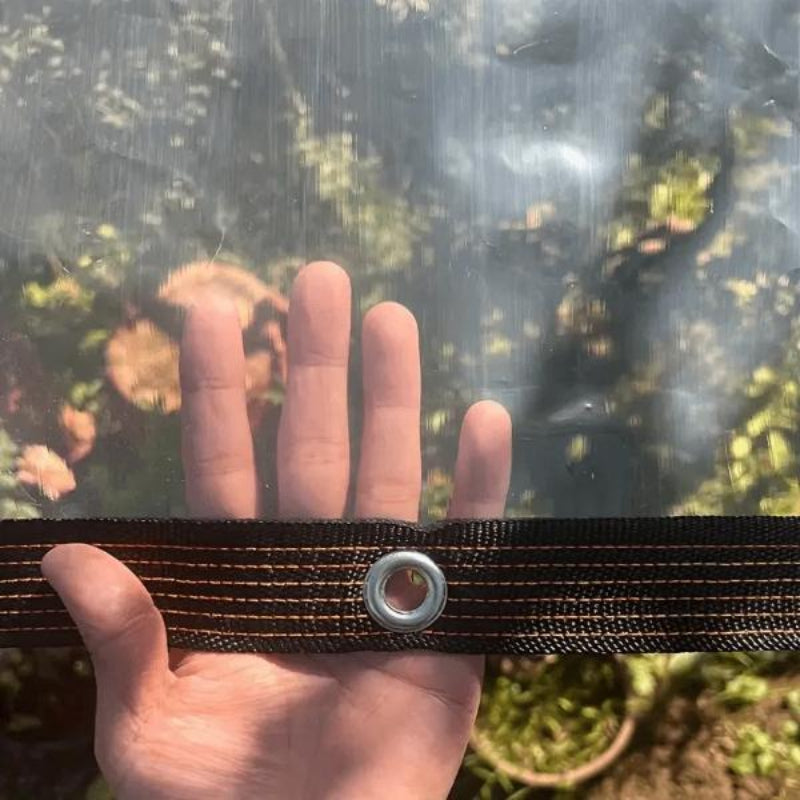 Nahaufnahme: Hand testet die Transparenz und Ösenverstärkung der OutdoorCover Schutzplane